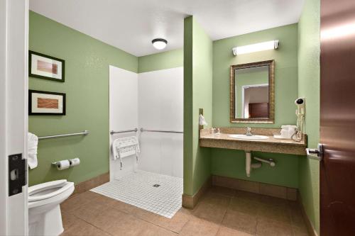 a bathroom with a toilet and a sink and a mirror at Comfort Inn New Orleans Airport South in Saint Rose