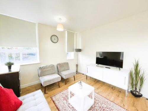 a living room with a flat screen tv and a couch at Maidstone Heights By Kasar Stays in Kent