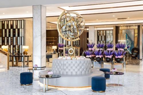 a lobby with a white couch and purple flowers at Waldorf Astoria Kuwait in Kuwait