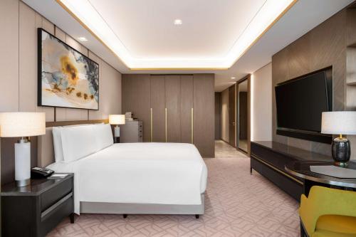 a hotel room with a bed and a television at Waldorf Astoria Kuwait in Kuwait