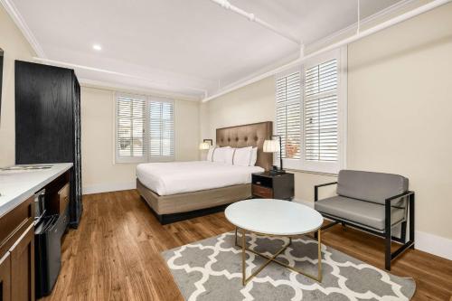 Hotel Petaluma, Tapestry Collection by Hilton في بيتالوما: غرفة نوم بسرير وطاولة وكرسي