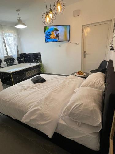 1 dormitorio con 1 cama grande y bañera en פנינת יוחאי-הצימר הזוגי, en Bar Yohai