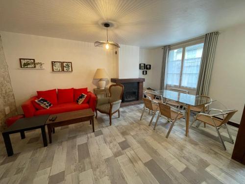un salon avec un canapé rouge et une table dans l'établissement La Maison de Marion, à Chaumont-sur-Loire