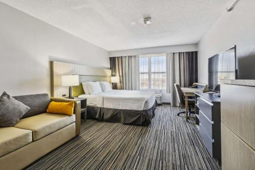 BensenvilleにあるCountry Inn & Suites by Radisson, Chicago O Hare Airportのベッドとデスクが備わるホテルルームです。