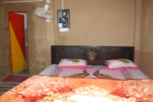 a bedroom with a bed with two pillows on it at 11 Gaon Mudhouse Homestay in Lansdowne