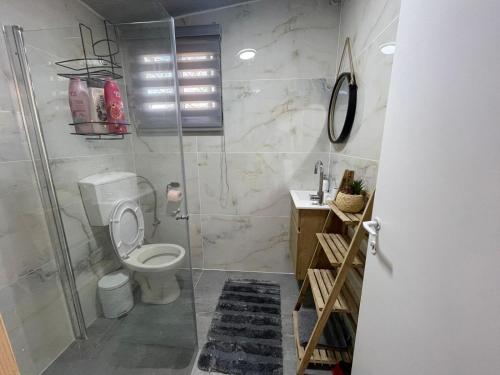 a bathroom with a toilet and a shower at פנינת יוחאי-הצימר הזוגי in Bar Yohai