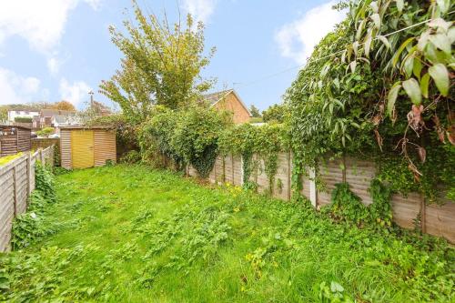 a backyard with a fence and a green yard at Sittingbourne Terrace in Sittingbourne