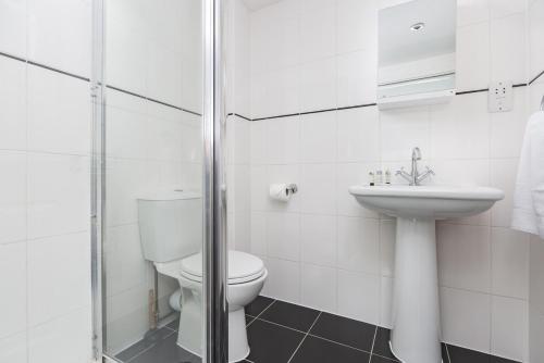 a white bathroom with a toilet and a sink at Sunny Terrace By Kasar Stays in Maidstone