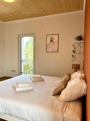 een slaapkamer met een groot wit bed en een raam bij Modern & Stylisch Penthouse - 112m2 - München&Airport in Freising