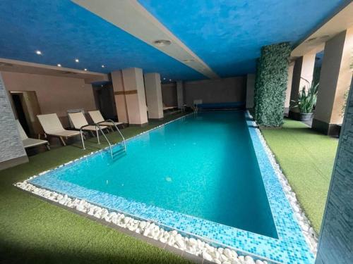 a large swimming pool in a hotel room at Charming comfortable apartment at Cornelia Deluxe Residence with free pool and SPA in Razlog