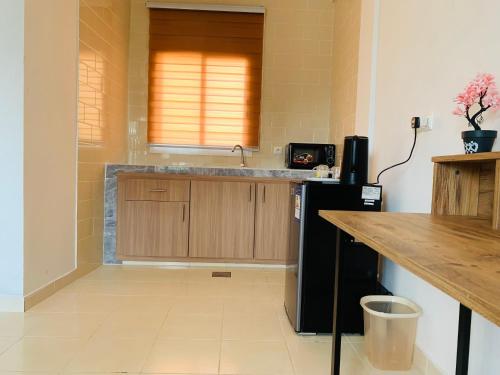 a kitchen with a counter and a black refrigerator at Namaste hotel & restaurant in Libreville