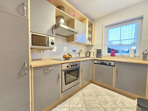 a kitchen with stainless steel appliances and a window at Ferienhaus Steuerbord im Bootshaus in Neßmersiel