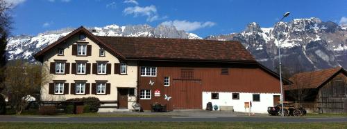 a large brown and white barn with mountains in the background at BnB Haag in Haag