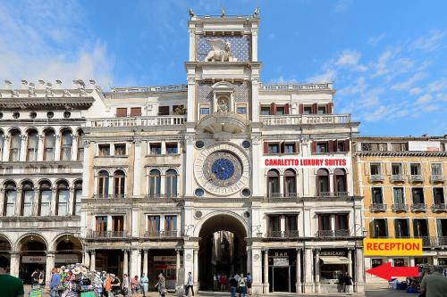 a building with a clock tower on top of it at Canaletto Luxury Suites - San Marco Luxury in Venice