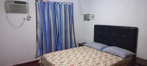Hause la rioja في لا ريوخا: غرفة نوم بها سرير ونافذة بها ستارة