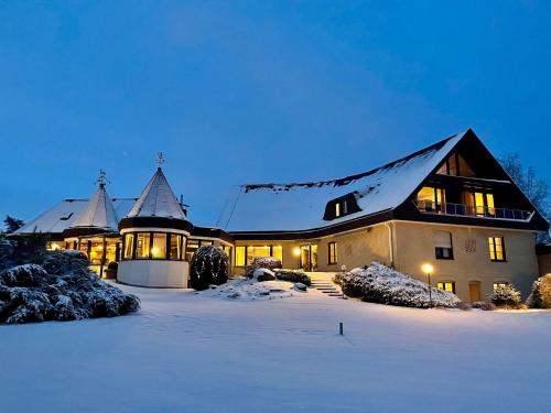 a large house in the snow at night at Landhotel Hubertus in Unterelsbach