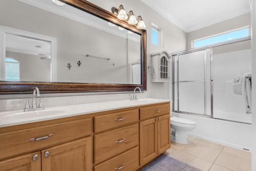 a bathroom with a sink and a toilet and a large mirror at Miramar Magic in Destin
