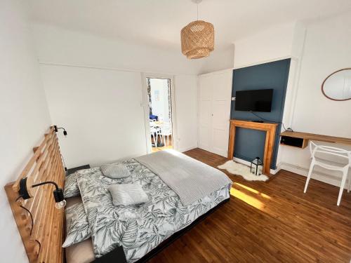 een slaapkamer met een groot bed en een televisie bij Les appartements d'Ostende in Calais