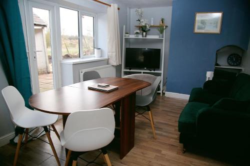 a living room with a table and a couch at Colney Lane Lodge in Colney