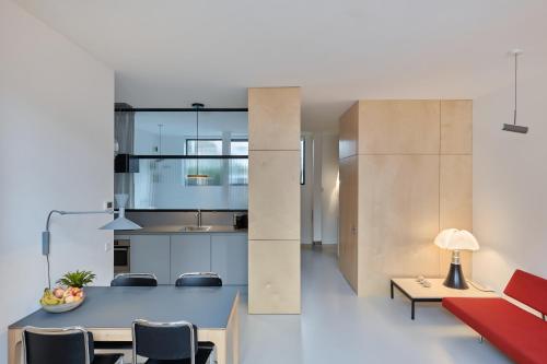 a kitchen and living room with a table and chairs at LE GARAGE Downtown serviced apartment in The Hague