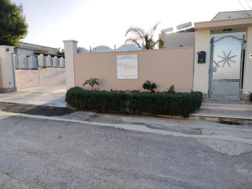 a white building with a gate and a fence at B&B Milena in Paceco