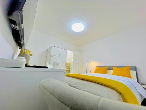 a bedroom with a bed with yellow sheets and a tv at Ensuite Luxury Bedroom In Purfleet in Purfleet