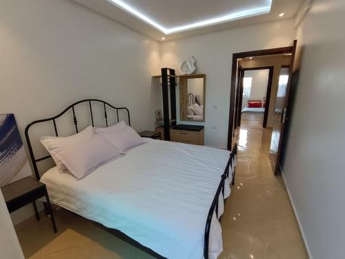 1 dormitorio con cama blanca y espejo en Cozy sunny apartment en Sale