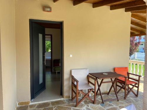 a patio with a table and chairs next to a door at Villa Panorea in Moraitika