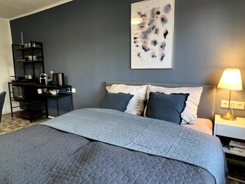 a bedroom with a large bed with blue pillows at Gemütliches Zimmer mit Bad und eigenem Eingang in Altstadtvilla in Arnsberg