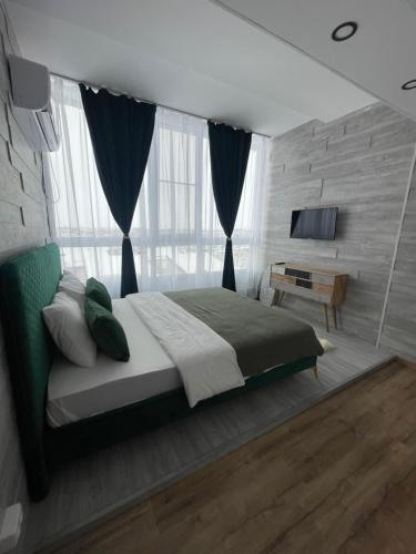 a bedroom with a large bed and a television at Marisah Residence #3 in Otopeni
