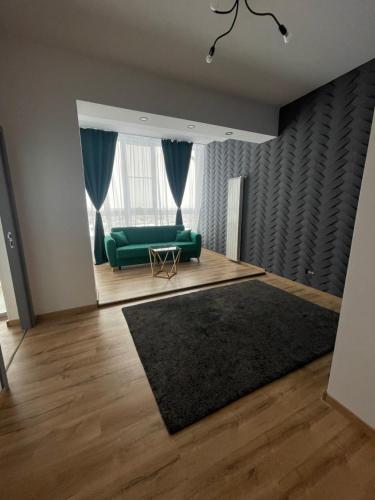 a living room with a green couch and a window at Marisah Residence #3 in Otopeni