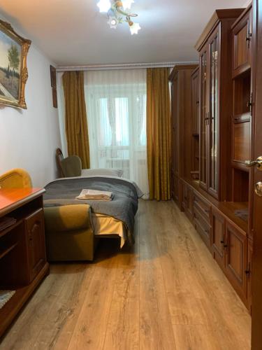 een slaapkamer met een bed, een dressoir en een raam bij Apartament Ultraconfort in Iaşi