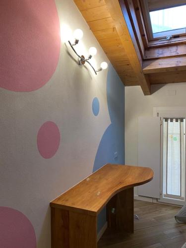 Zimmer mit einem Tisch und einer Wand mit Polka-Punkten in der Unterkunft Appartamento nel cuore di Vigevano in Vigevano