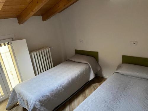 2 camas en una habitación con ventana en Appartamento nel cuore di Vigevano, en Vigevano