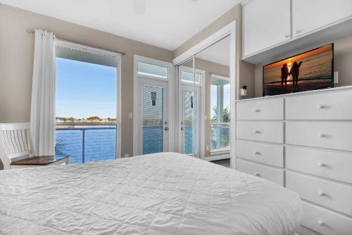 1 dormitorio con 1 cama y vestidor con TV en Destiny Beach Villas #11A- Beach Oasis, en Destin