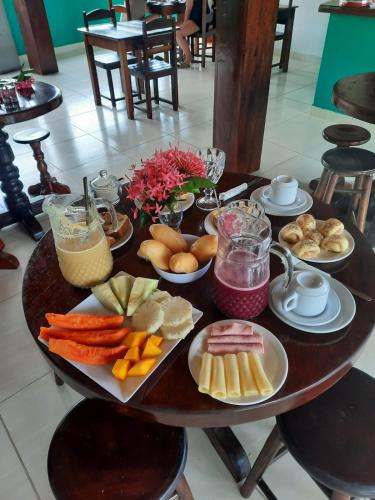 a wooden table with plates of food on it at Pousada Iakã Boipeba in Ilha de Boipeba
