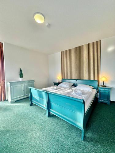 a large blue bed in a room with two tables at Gästehaus Weserblick am Weser-Sandstrand in Berne