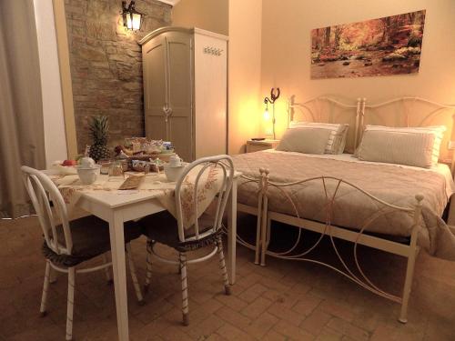 1 dormitorio con 1 cama, mesa y sillas en Relais Cà del rio en Botteghino