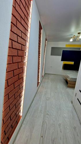 Cette chambre est dotée d'un mur et d'un sol en briques. dans l'établissement ULTRA NEW, à Bălţi