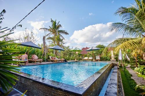 una piscina en un resort con palmeras en Taos House Lembongan By DeWizZ Management, en Nusa Lembongan