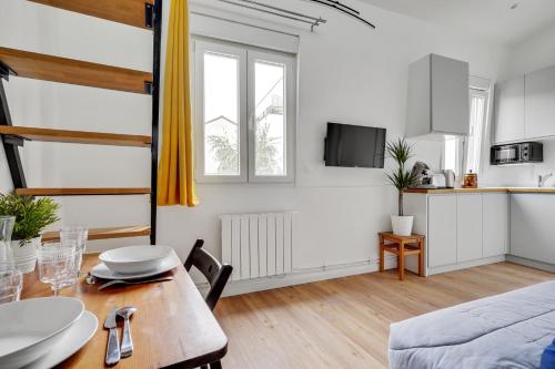 Ce petit appartement comprend une table à manger et une cuisine. dans l'établissement Studio avec mezzanine - Wifi - Proche Paris (R8), à Montreuil