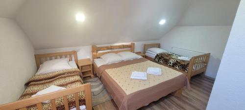 um pequeno quarto com duas camas e uma mesa em Готель RIVER HILL em Mykulychyn