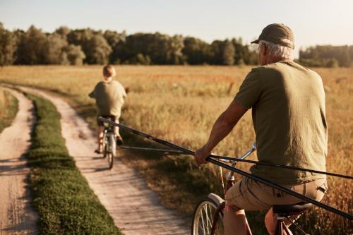 two men riding bikes down a dirt road with a rope at Villa Oliva in Sanlúcar la Mayor