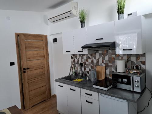 a kitchen with white cabinets and a black counter top at U Adama in Wieliczka