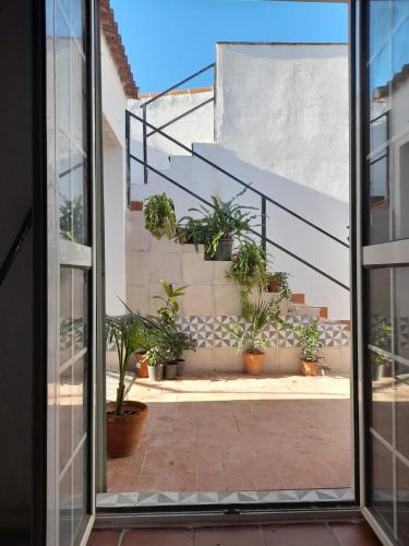 a view from a window of a courtyard with potted plants at Villa Oliva in Sanlúcar la Mayor