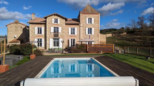 une grande maison avec une piscine devant dans l'établissement Chambres et tables d' hôtes, à Manglieu