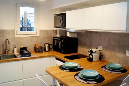 a kitchen with a counter top with plates on it at The Silent T1 city center JO 2024 PARIS in Chevreuse