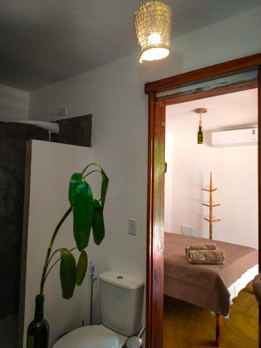 a room with a bed and a plant next to a door at Icarai Kite House in Icaraí