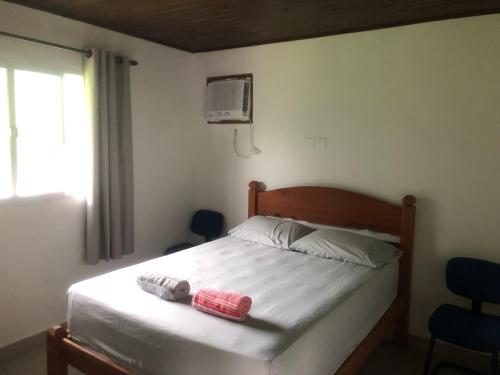 1 dormitorio con 1 cama con 2 toallas en Casa Cachoeira Paraty en Parati