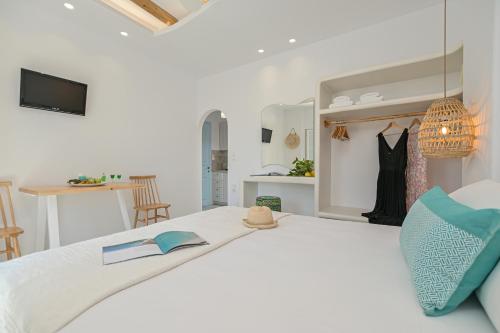 a white bedroom with a bed with a book on it at Sofi pension in Naxos Chora